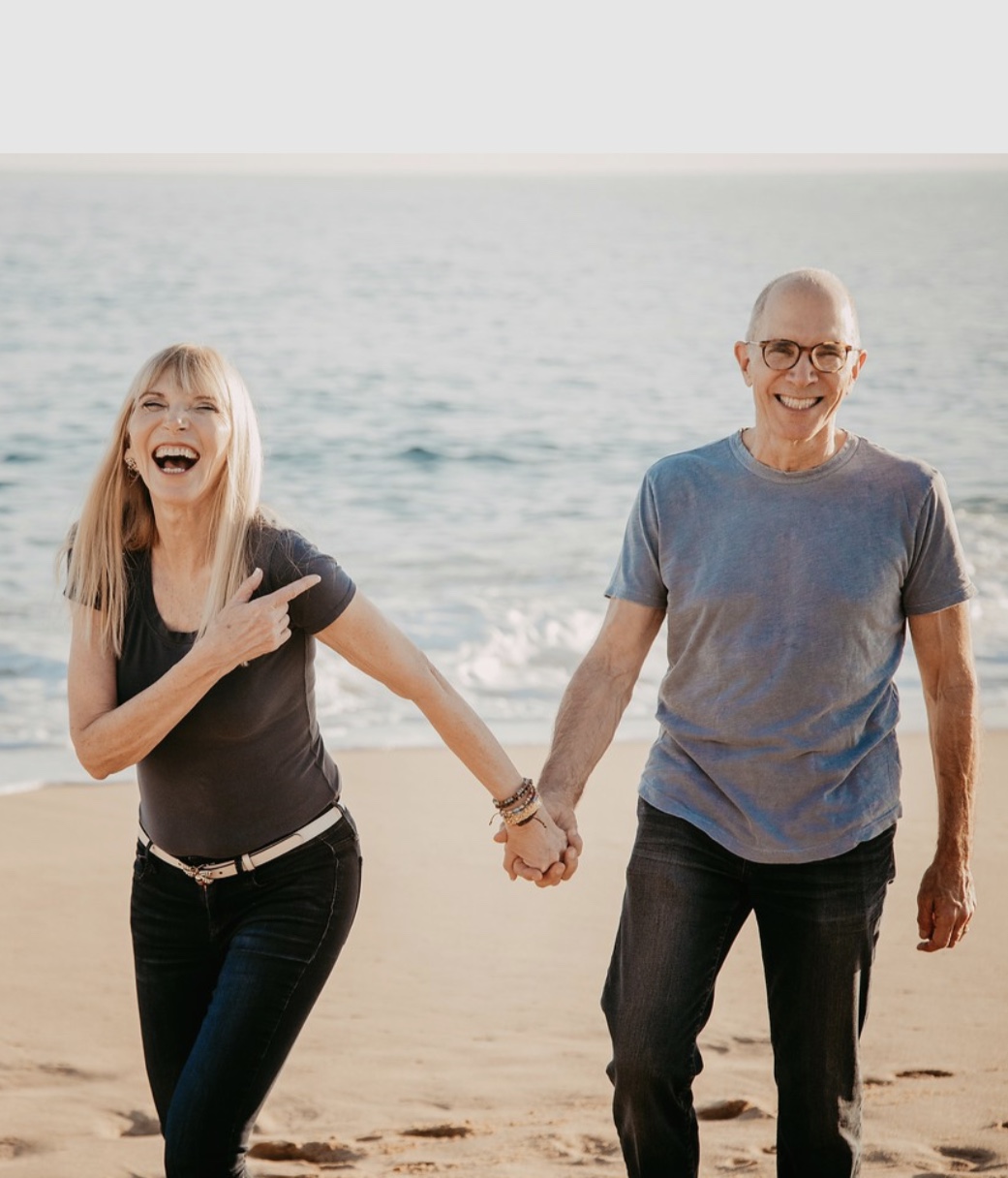 Dr. Tager and his wife walking on a beach